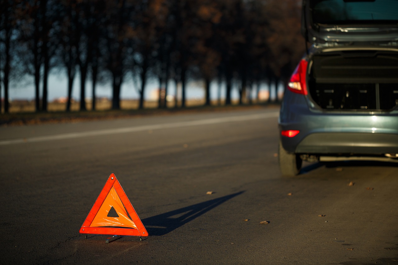 Warning Triangle With A Broken Down Car indicating roadside assistance is needed