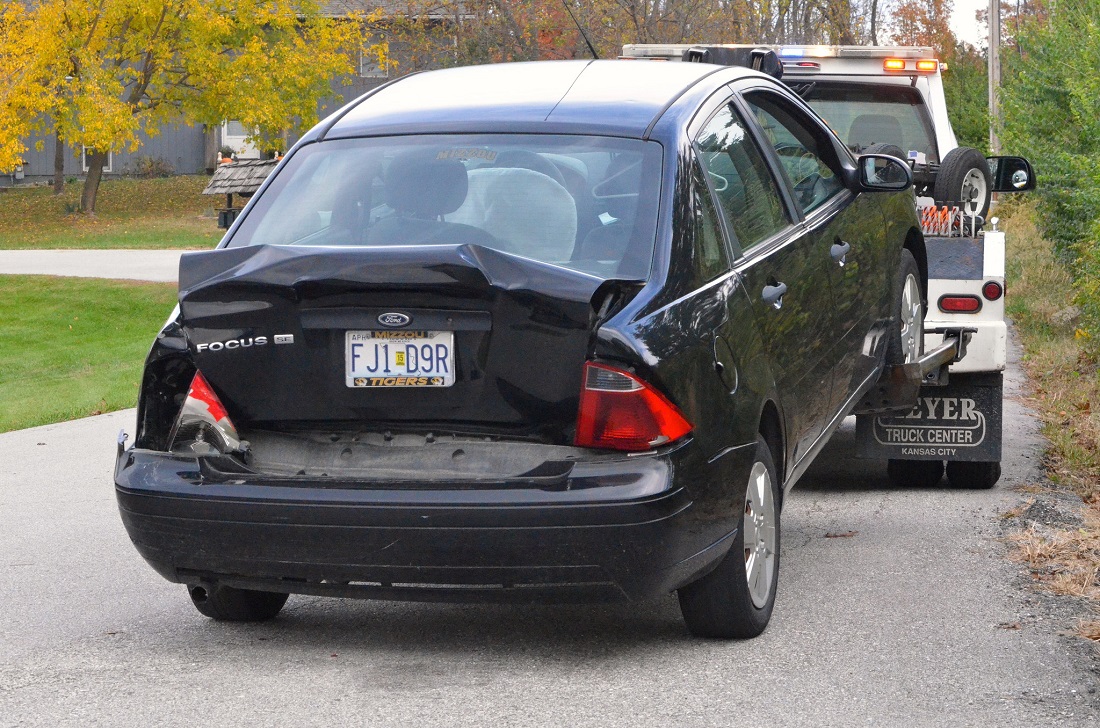 Wheel Lift Tow Truck Servicing A Black Sedan