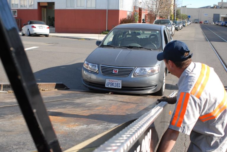 Tow Truck Driver Loading a Saturn Onto A Flatbed